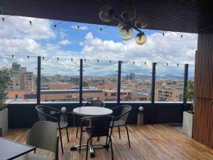 a table and chairs on a balcony with a view of a city at Luxury Loft Chico Piscina etc. in Bogotá