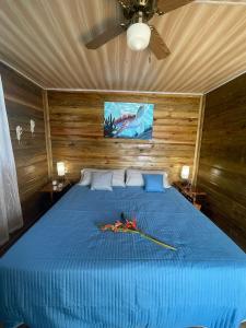 1 dormitorio con cama azul y techo en Ponci’s Gate to Gaia Holistic Center en Bocas Town