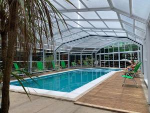 a woman sitting in a chair next to a swimming pool at Oasis Apart-Spa in Las Gaviotas