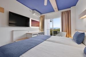 ein Schlafzimmer mit einem großen Bett und blauer Decke in der Unterkunft Hotel Pabisa Sofia in Playa de Palma