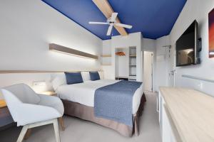 ein Schlafzimmer mit einem weißen Bett und einer blauen Decke in der Unterkunft Pabisa Sofia in Playa de Palma