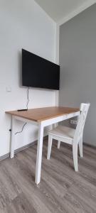 a white desk with a television on a wall at Zweibettzimmer "Grau" in zentraler Lage in Bremen