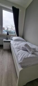A bed or beds in a room at Zweibettzimmer "Grau" in zentraler Lage