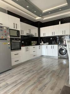 Il comprend une grande cuisine avec des placards blancs et du parquet. dans l'établissement Sunterra Resort 01 bedroom Apt., à Charm el-Cheikh