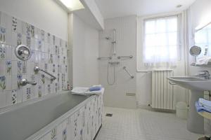 a bathroom with a shower and a tub and a sink at La Vallée 