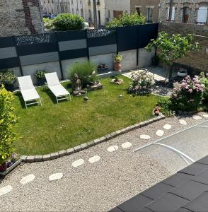 a garden with two chairs and some flowers at La Petite Maison de Jane in Reims
