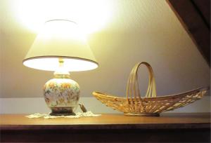 una lámpara y una cesta en una mesa en Gîte Le Sarment, en Donnenheim
