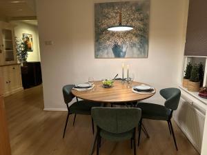uma mesa de jantar com quatro cadeiras e uma vela em De Lijster em Bergen