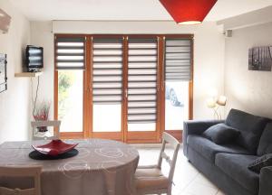 ein Wohnzimmer mit einem Sofa und einem Tisch in der Unterkunft Le Cocon appart avec parking privé & terrasse in Sainte-Croix-en-Plaine