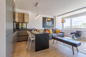 馬德里的住宿－Apartamento Plaza Colon Colon II，厨房以及带沙发和桌子的客厅。