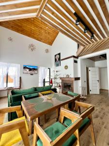 a living room with a wooden table and a green couch at Villa Pelahia in Slavske