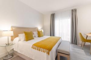 a bedroom with a large bed with yellow pillows at Apartamento Enfrente Palacio Royal Palace I in Madrid