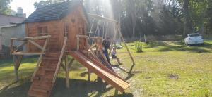 a man and a child standing next to a wooden play structure at Alquiler temporario zona sur MDQ in Mar del Plata