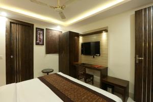 a hotel room with a bed and a desk and a television at Hotel The Paramont at Delhi Airport in New Delhi
