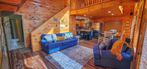 a living room with two blue couches and a kitchen at Dream Mountain Delight in Grassy Creek