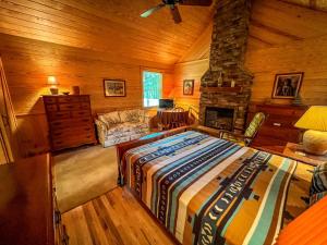 ein Schlafzimmer mit einem großen Bett und einem Kamin in der Unterkunft Edelweiss Cabin in Jefferson