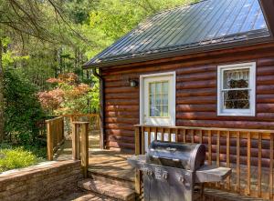 eine Holzhütte mit einem Grill davor in der Unterkunft Edelweiss Cabin in Jefferson