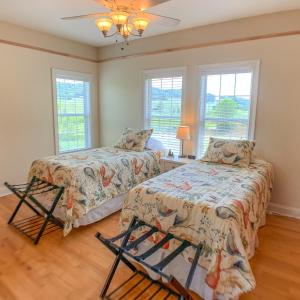 2 camas en una habitación con 2 ventanas en Carolina Pines, en Grassy Creek