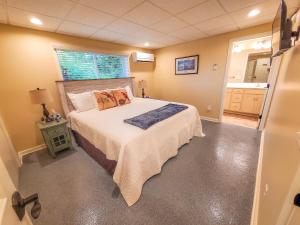 een slaapkamer met een bed met een witte sprei en een raam bij Grapevine Retreat in West Jefferson