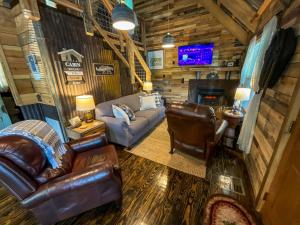 a living room with couches and a tv in a cabin at Reddies River Retreat - New Rental 2023 in Millers Creek