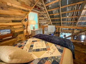 a bedroom with a bed in a log cabin at Reddies River Retreat - New Rental 2023 in Millers Creek