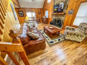 uma sala de estar com um sofá de couro e uma lareira em Riverview Ridge em Piney Creek