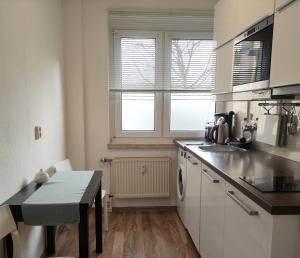 una cocina con fregadero y mesa. en Apartment L - comfort en Leipzig