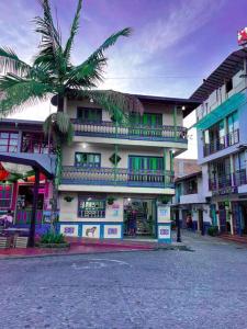 ein Gebäude mit einer Palme davor in der Unterkunft Apartamento Parque Central Guatapé in Guatapé