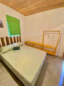 1 Schlafzimmer mit 2 Betten und einem grünen Fenster in der Unterkunft ((Casa brisa das águas)) Rota ecológica de milagres in Pôrto de Pedras + 8 Fotos