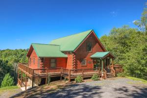 uma grande cabana de madeira com um telhado verde em Dream Mountain Lodge em Grassy Creek