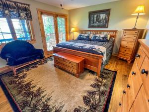 een slaapkamer met een bed en een stoel erin bij Jasmine Heights - New Rental 2023 in West Jefferson