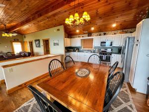 een keuken en eetkamer met een houten tafel en stoelen bij Jasmine Heights - New Rental 2023 in West Jefferson