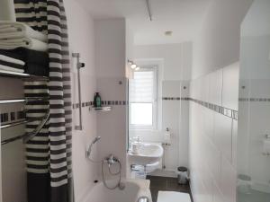 Un baño blanco con lavabo e inodoro. en Apartment L - comfort, en Leipzig 23 fotos más