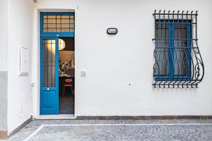 uma porta azul e janela num edifício branco em Relais Mangano - Apartment - by HOST4U em Brescia