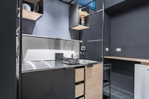 uma cozinha com um lavatório e armários de madeira em Relais Mangano - Apartment - by HOST4U em Brescia