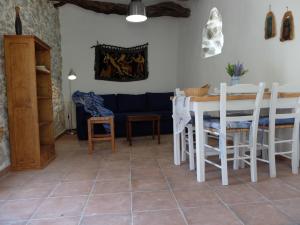 a living room with a table and a blue couch at Kavousi Cottages - O Stavlos in Kavoúsion