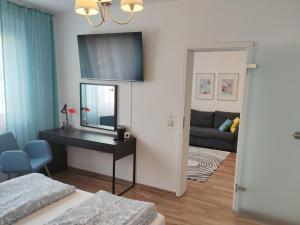 1 dormitorio con escritorio, espejo y sofá en Apartment L - comfort en Leipzig