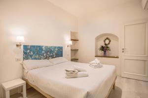 ein Schlafzimmer mit einem weißen Bett mit Handtüchern darauf in der Unterkunft Cinque Passi - Sweet Dreams in Florence in Florenz