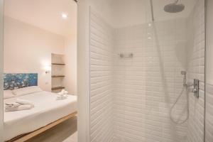 ein weißes Bad mit Dusche und ein Bett in der Unterkunft Cinque Passi - Sweet Dreams in Florence in Florenz