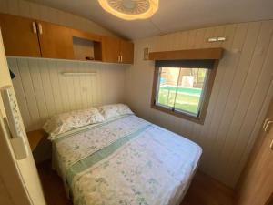 a small bedroom with a bed in a trailer at Mobil home Calicanto in Masía Aldamar
