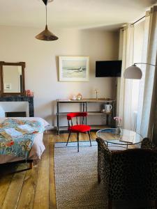 ein Schlafzimmer mit einem Bett und einem roten Stuhl in der Unterkunft Villa Tourelle in Dinan