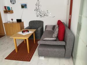 ein Wohnzimmer mit einem Sofa und einem Tisch in der Unterkunft Arberblick - b45689 in Schöfweg