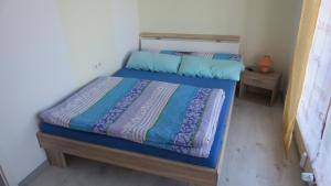 Schlafzimmer mit einem Bett mit blauer Decke in der Unterkunft Arberblick - b45689 in Schöfweg