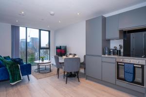 eine Küche und ein Wohnzimmer mit einem Tisch und Stühlen in der Unterkunft City Cosy 1 bed - Perfect for Long Stays By Valore Property Services in Manchester