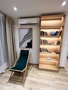 a room with a chair and a book shelf at Perle au centre ville avec vue mer et montagne in Saint-Denis