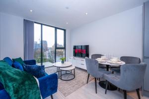 ein Wohnzimmer mit einem Sofa und einem Tisch in der Unterkunft City Cosy 1 bed - Perfect for Long Stays By Valore Property Services in Manchester