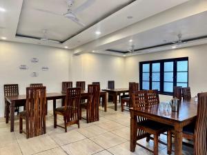 a dining room with wooden tables and chairs at Main Street Inn in Srinagar