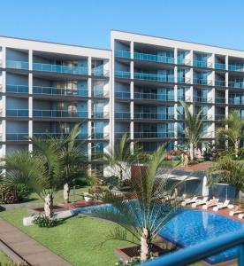 een appartementencomplex met een zwembad en palmbomen bij Madeira Residence Apt. 80 in Funchal