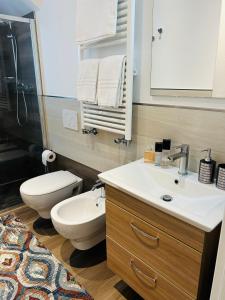 a bathroom with a sink and a toilet and a mirror at Menotti Attico-Flexrent Immobiliare Abissinia in Riccione +54 photos
