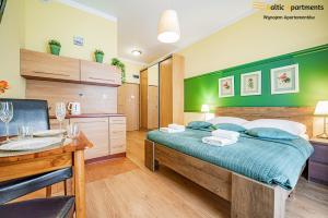 sypialnia z łóżkiem z zielonym akcentem w obiekcie Baltic Apartments - Apartamenty Korony Piastów w Świnoujściu
